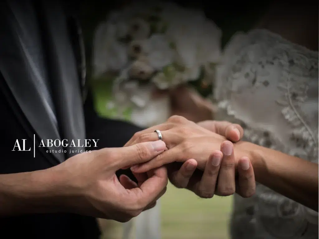 Manos de dos personas que se van a casar, poniéndose las argollas de matrimonio , viendo la Diferencia entre unión civil y matrimonio: Aspectos claves en Chile