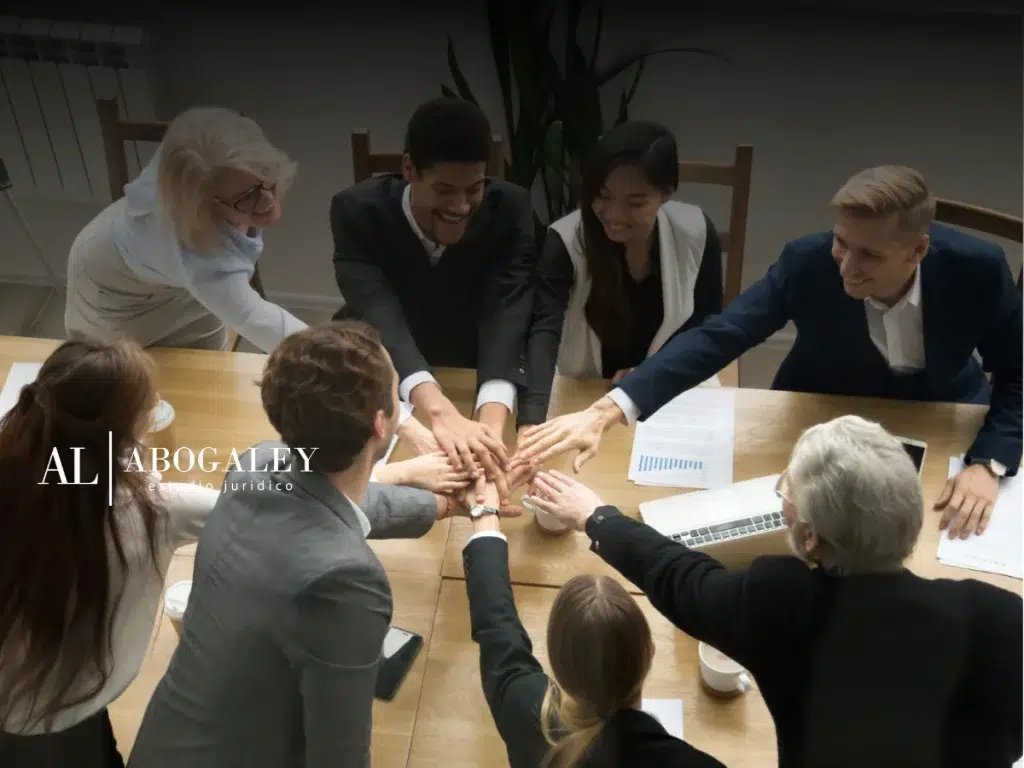 Grupo de trabajadores en traje formal, reunidos y con las manos unidas para crear un sindicato y analizando Qué es un sindicato y para qué sirve en Chile