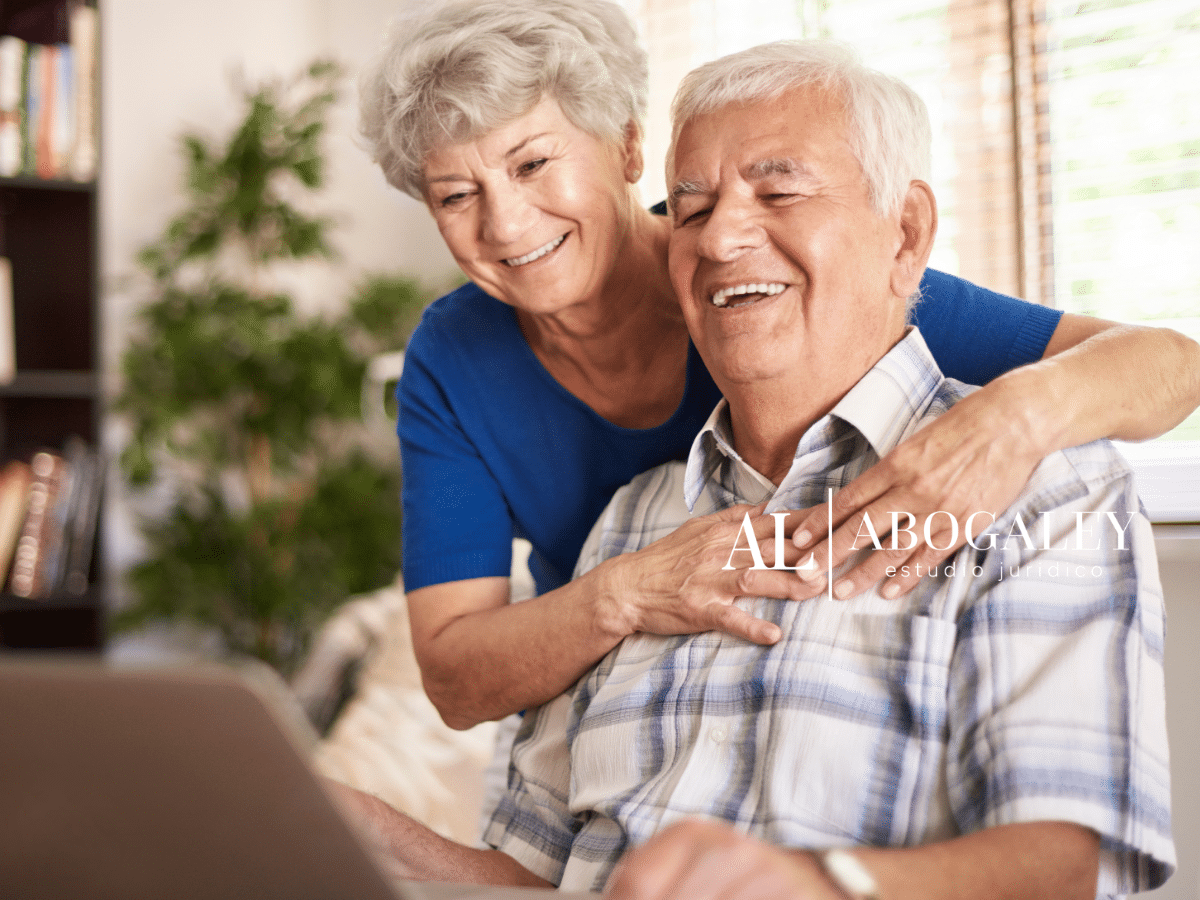Pareja de adultos mayores viendo en el computador que establece la Ley integral de personas mayores en Chile.